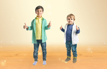Boys making OK sign over ocher background