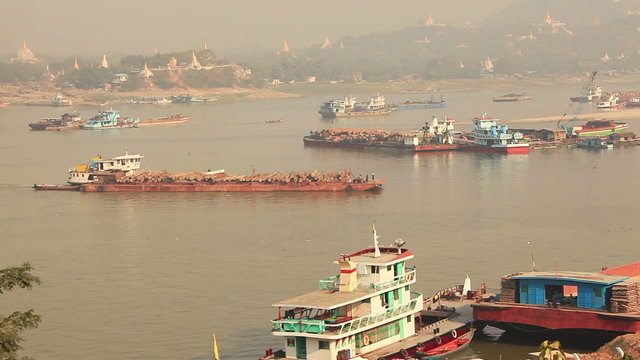 Transportation teakwood. There are many Buddhist temples on a background.  Irrawaddy river, Myanmar.