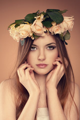 Spring girl. Young elegant woman with roses bouquet in hair