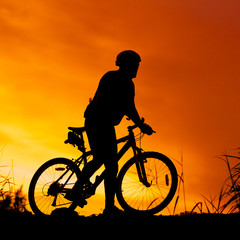 silhouette of bicycle rider at sunset
