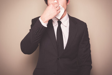 Businessman blowing his nose