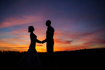 Fototapeta na wymiar loving couple holding hands at sunset