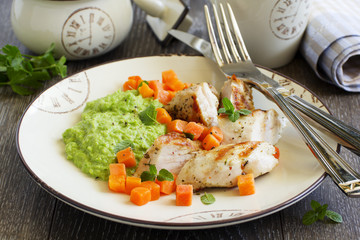 Pieces of chicken with pea puree and pumpkin.