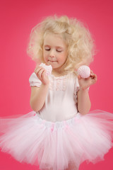 Little girl in a tutu skirt on pink background