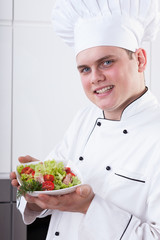 Male chef holding salad