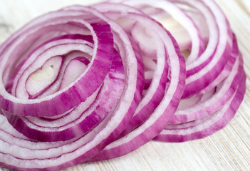 slices of red onions on white wooden surface