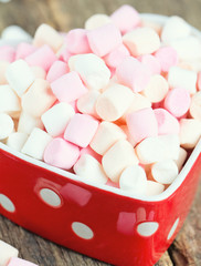 marshmallows in heart shape bowl on a wooden table