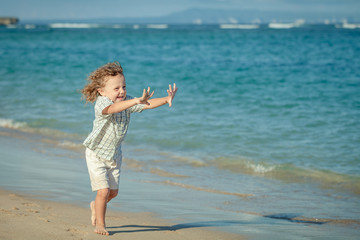 little boy running on the beach in the day time