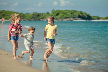 Naklejka premium happy kids playing on beach