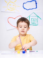 Portrait of a cute boy playing with paints