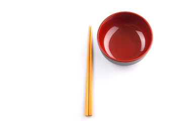 An empty bowl with a pair of chopsticks over white background