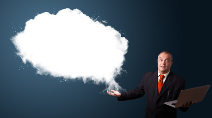 Businessman holding a laptop and presenting abstract cloud copy