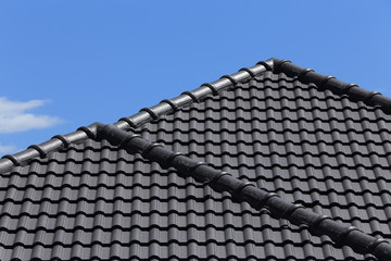 black tiles roof on a new house with blue sky