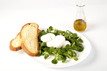 Treccia di mozzarella fresca con valeriana e fette di pane