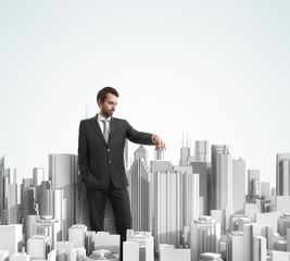 Young businessman and model of a modern city