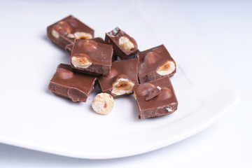 Шоколад с орехами на белой тарелке