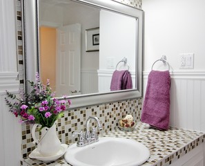 Country bathroom with purple flowers in vase and purple towel