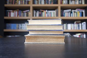 Libros antiguos con librería al fondo