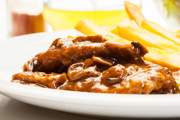 Pork chop with sauce, mushrooms and chips