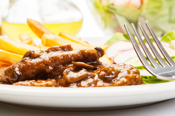 Pork chop with sauce, mushrooms and chips