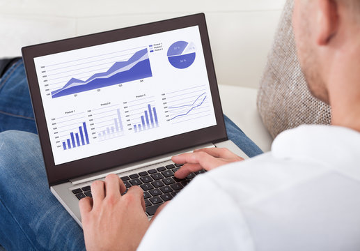 Businessman analyzing graphs on his laptop - Powered by Adobe