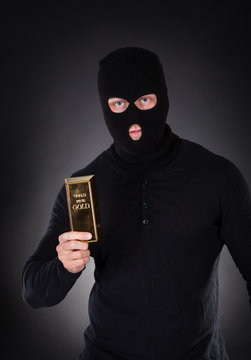 Robber holding a gold bullion bar