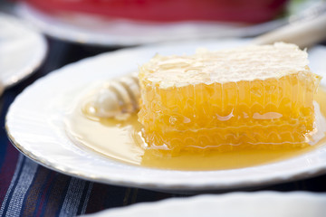 Honey and wooden stick at the background