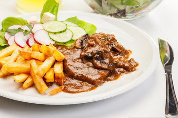 Pork chop with sauce, mushrooms and chips