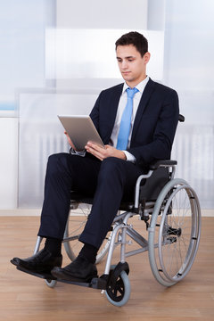 Businessman Using Digital Tablet On Wheelchair
