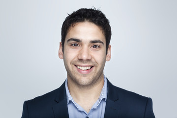 Confident business man smiling on grey background