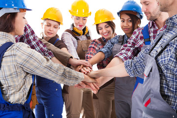 Diverse group of construction workers stacking hands