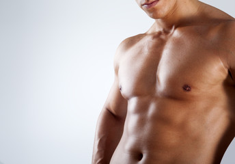 Healthy muscular young man on grey background