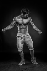 Fototapeta na wymiar Strong Athletic Man Fitness Model Torso showing big muscles over