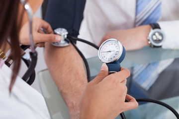 Doctor Checking Blood Pressure Of Businessman