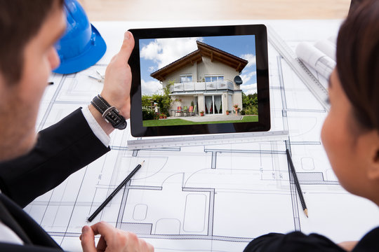 Architects With Digital Tablet Looking At House
