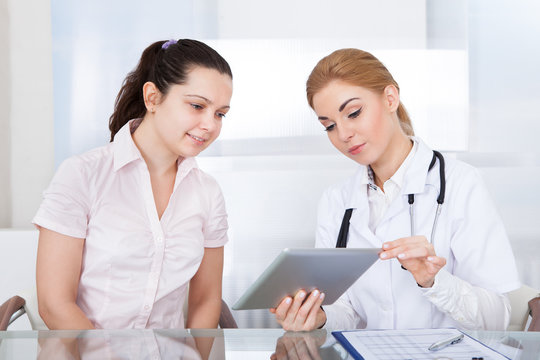 Doctor And Patient Looking At Laptop