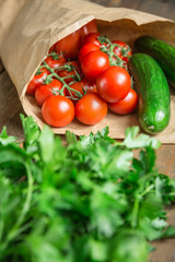 Ripe tomatoes and vegetables in paper bag 