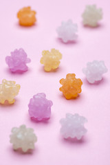ピンク色の背景に散らばった金平糖