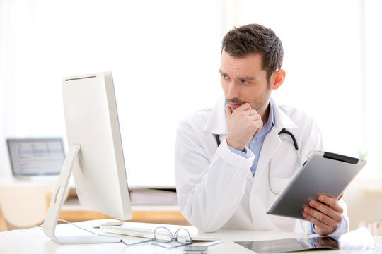 Portrait of a young doctor using tablet at work