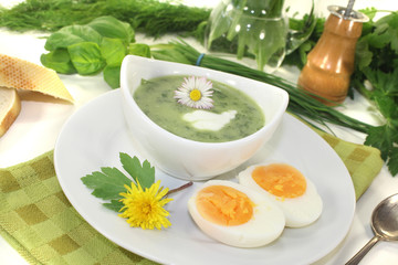 Kräutersuppe mit Eiern und Sahneklecks