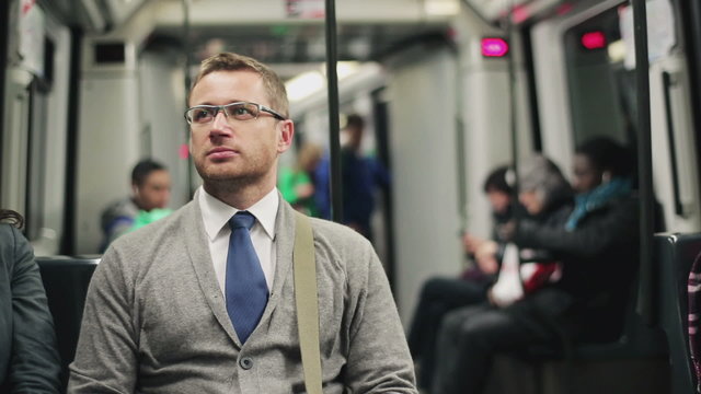 Pensive businessman riding by the subway, steadycam shot