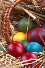 Colourful Easter eggs in a basket and in the straw