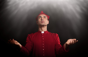 Praying man in historical medieval cardinal's vestments