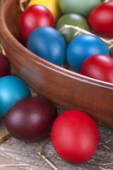 Colorful Easter eggs in the bowl and straw
