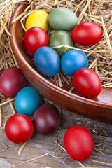 Colorful Easter eggs in the bowl and straw