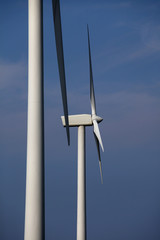 Two wind turbines against blue sky