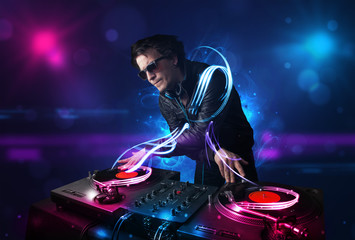 Disc jockey playing music with electro light effects and lights