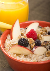 Bowl of steel cut oats served with fresh fruit and honey