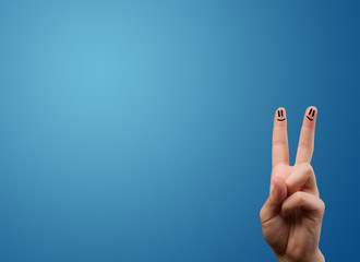 Happy smiley face fingers looking at empty blue background copy