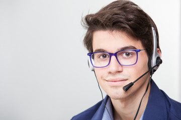 Close-up portrait of young smiling business man with headset